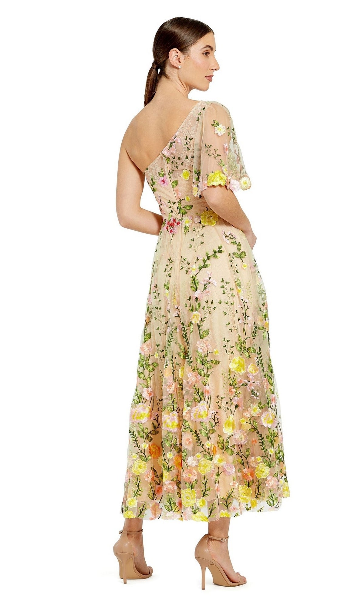 A woman models the Mac Duggal 68607 One-Shoulder Midi Party Dress in light pink with floral embroidery and tea-length silhouette, styled with nude high heels, standing against a white background.